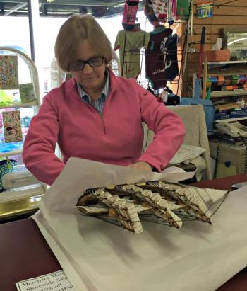 Emma Benner carefully wraps up a model ship purchased by a Cash Mob customer. KATRINA CLARK/Boothbay Register