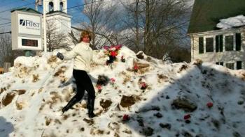 Brenda L. Blackman climbs to the top of the snowbank to decorate it. Courtesy of Shelley Smith.
