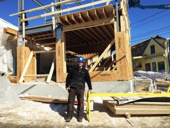Garron Heath, a supervisor for Peachey Builders, stands outside the structure being built at 8 Wharf Street on March 6. SUZI THAYER/Boothbay Register
