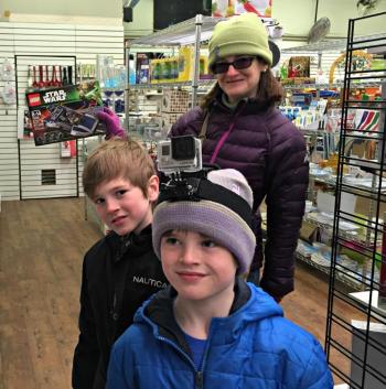 Elizabeth O'Connor holds up a Lego set picked out by her sons, Colin Wright, middle, and Brennan Wright, front, during the Cash Mob Saturday, March 28. KATRINA CLARK/Boothbay Register