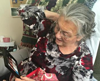 Peggy Frantz looks at a photo taken at a recent high school reunion. She missed the last one due to illness, but hopes to attend the next one. KATRINA CLARK/Boothbay Register