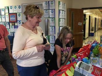 Suzanne “Nana” Shields, left, pays for books for her grandchildren at the book fair. On her right is Megan Leeman. Not pictured: Cassidy Leeman. KATRINA CLARK/Boothbay Register