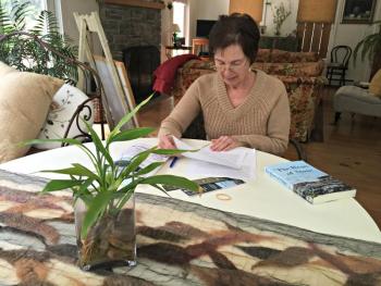 Author Cheryl Blaydon works at a table in her home. KATRINA CLARK/Boothbay Register