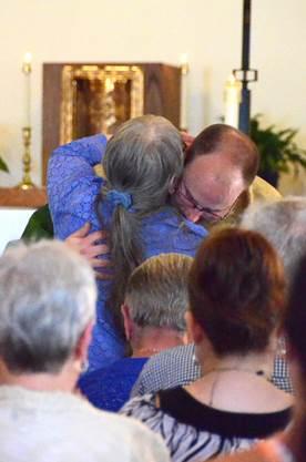 Father Steven Cartwright gives his mother, Lynn, a hug at his first Mass. Courtesy of Lois Czerniak, Roman Catholic Diocese of Portland