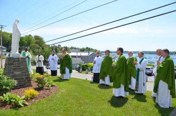 Father Steven Cartwright and visiting priests gathered for prayers before a statue of the Blessed Mother, which Cartwright's father helped to place outside the church. Courtesy of Lois Czerniak, Roman Catholic Diocese of Portland