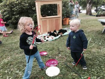 Grace Daley, 3, and brother Charlie Daley, 2, of Hingham, Massachusetts, enjoy making bubbles at Summerfest on the Wiscasset common on July 26. SUSAN JOHNS/Wiscasset Newspaper