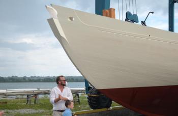 Noah Barnes and his son, Oscar, stand at the bow of the Ladona on the St. George River before the soft relaunching of the historic vessel. (Photo by Lynda Clancy)