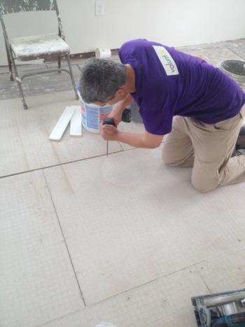 A volunteer with www.lowernine.org works on installing flooring in a new home. Courtesy of Rick Prose
