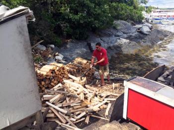 Greg Miller, a grandson of Bennie Alice Moore, chops wood for the fire that cooks the lobsters and clams. SUZI THAYER/Boothbay Register