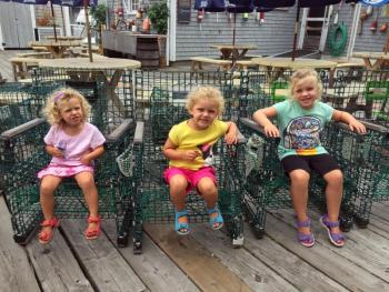 Three sisters take a break in lobster trap chairs in front of Fisherman’s Wharf in Boothbay Harbor on Aug. 20. SUZI THAYER/Boothbay Register
