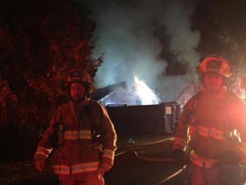 Firefighters walk down West Alna Road in Alna as work continues on putting out a house fire. SUSAN JOHNS/Wiscasset Newspaper