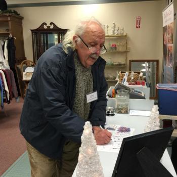 Richard Macdonald of Macdonald Stained Glass finds the answer to how much the thrift store donated to local healthcare last year during the scavenger hunt. KATRINA CLARK/Boothbay Register