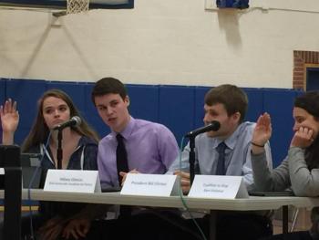 Junior Jacob Leonard, in character as Hillary Clinton, answers a question from the conservative side of the debate on Dec. 21. To his left is Alexis Welch as a representative for Americans for Responsible Solutions, and to his right are Carter Babcock as former President Bill Clinton and Molly Thibault as a representative of the Coalition to Stop Gun Violence. KATRINA CLARK/Boothbay Register