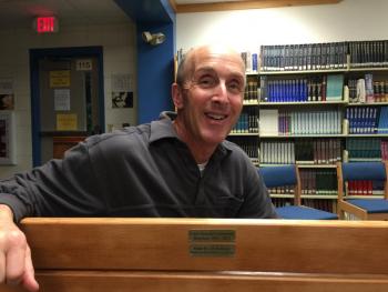 School Resource Officer Larry Brown sits on the “Seahawk Bench” made from the former bleacher boards in the Porter Memorial Gymnasium. KATRINA CLARK/Boothbay Register