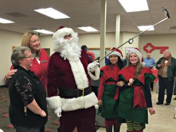 Santa takes a selfie in Key Bank with Donna Gregory, far left, and Kimberly Gates while elves Lovely Uberita and Sierra Murray, far right, look on. KATRINA CLARK/Boothbay Register