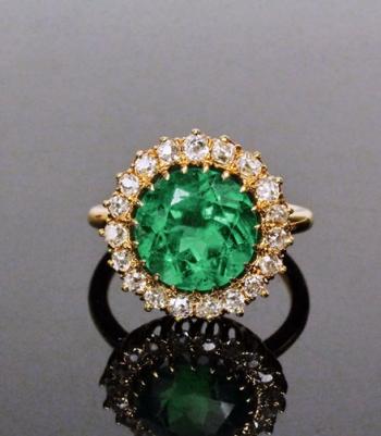Antique 18K gold ring with a 3.96 ct. brilliant cut emerald surrounded by diamonds
