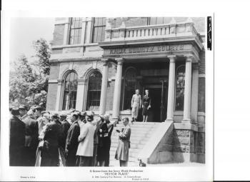 A behind-the-scenes shot in ‘Peyton Place’ of Diane Varsi and Russ Tamblyn on the steps of Knox County Courthouse with extras (locals) in the foreground. (Courtesy Willard Carroll)