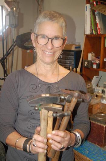 Anita Roelz holds antique hammers she uses to fashion silver jewelry. ART MAYERS/Boothbay Register