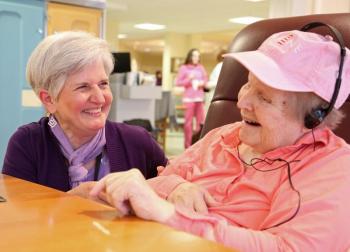 St. Andrews Village volunteer Holly Fulmer with a Gregory Wing resident who is enjoying the iPod she received as part of the Village’s Music and Memory program. Fulmer interviews residents and their families to learn what music residents enjoy most and then gives them iPods stocked with highly personalized selections of music. Courtesy of LincolnHealth
