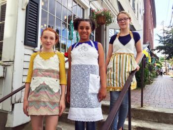 Madison Browne, left, Nylaina Wilson and Brooke Lindsay model some of the PaperDoll Aprons during the Wiscasset Art Walk on June 30. SUZI THAYER/Boothbay Register