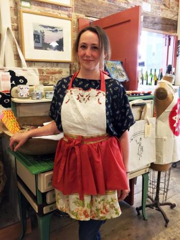 Dana Browne-Spinney models one of her designs, from PaperDoll Aprons, at Treats in Wiscasset. SUZI THAYER/Boothbay Register