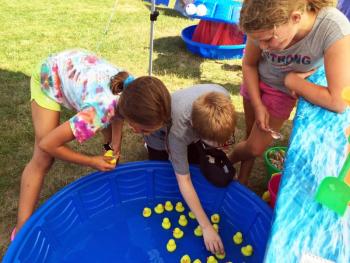 Azalea Bennett mans the Duck Hunt booth, while Hannah Moreno and Eric Maki try their luck at winning lollipops. SUZI THAYER/Boothbay Register