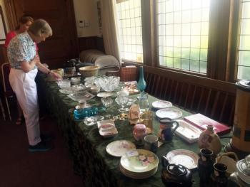 Liz Furber inspects some of the treasures at the Southport United Methodist Church during the Southport Country Fair and Lobster Roll Luncheon on July 20. SUZI THAYER/Boothbay Register