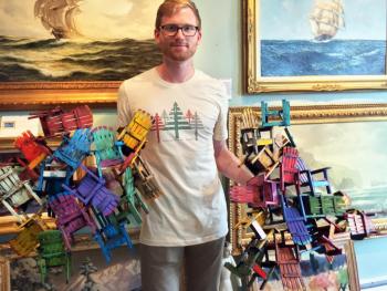 Ryan Hinton holds two pieces of three-dimensional wood art by contemporary reclaimed wood artist Paul Jacobsen. SUZI THAYER/Boothbay Register