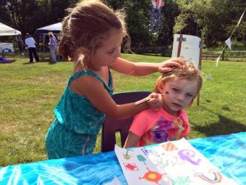 Sarah Harris paints a picture on Elizabeth Wallace’s cheek. SUZI THAYER/Boothbay Register