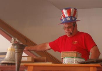 Fire Chief Gerald Gamage rings the bell to open the auction. ART MAYERS/Boothbay Register