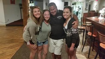 Eastwind Captain Bradley Elder receives a hug from three kayakers, pictured from left, Lindsay Blake, Jessica Burns and Whitney Ethridge, rescued Aug. 29 by his crew during a cruise around the bay. Courtesy photo