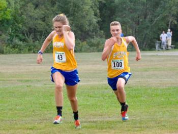 In most meets, boys and girls races are separate. But on Sept. 7, they ran at the same time. Here, Faith Blethen battles freshman Rowan Kristan at the finish line. Kristan edged out Blethen by one second but Blethen easily won the girls race.. Courtesy of Kerrin Erhard Photo of Failth Blethen and Rowan Kristan