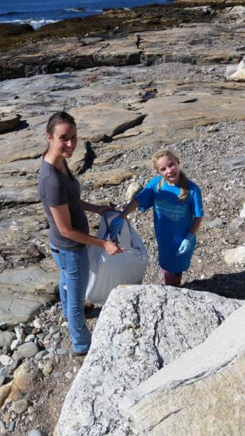 Rachel St. Vincent, left, and Hannah Hills clean up a beach. Courtesy of Elaine Jones