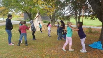 Woolwich Central School students play traditional Wabanaki games in front of the DRA birch bark wigwam, which was constructed with student involvement. Courtesy photo
