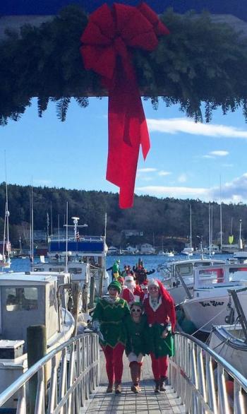 The Clauses’ North Pole entourage makes its way up the Town Landing ramp ... It must be Harbor Lights in Boothbay Harbor! LISA KRISTOFF/Boothbay Register