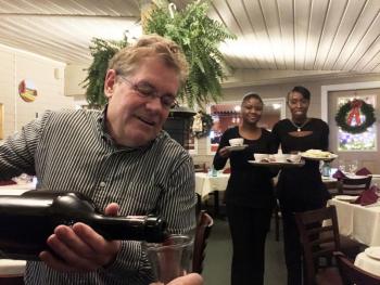 Ports of Italy manager Jeff Teel pours wine from a three-liter magnum on Friday, Dec. 2. SUZI THAYER/Boothbay Register