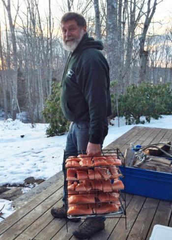 Jon Lewis heads to his smoker with a rack of his special brine-marinated salmon. Courtesy of Sue Mello