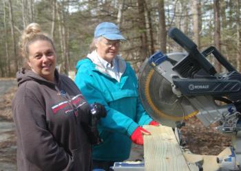 Melanie Green and Pam Burke chop a deck support. ART MAYERS/Boothbay Register