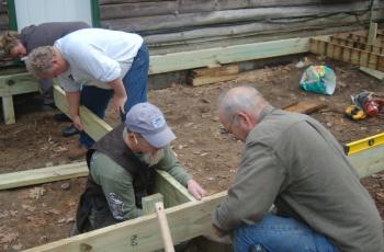 House captain Chris Higgins, left, lines up a a deck support for volunteers Rick Green and Alan Miller. ART MAYERS/Boothbay Register