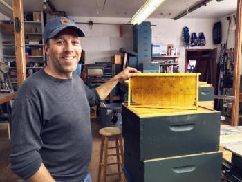 Tim Forrester holds a beehive frame in his Woolwich workshop. SUZI THAYER/Boothbay Register