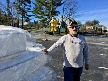 Tim Brown of Brown’s Wharf stands in the parking lot next to some of the new mattresses that will replace the ones given away May 4. SUZI THAYER/Boothbay Register