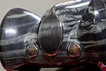 “Drive” is a quartzite Jaguar with stainless steel trim that cruises on a Brazillian cherry highway atop a steel base, by Andreas von Huene of Arrowsic. Courtesy of Dennis Griggs Andreas von Huene