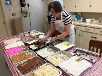 Peggy Stengel cuts a lot of cake for the luncheon. SUZI THAYER/Boothbay Register