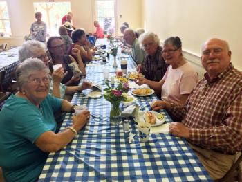 Diners enjoy the lobster rolls, chicken salad rolls, hot dogs and cake. SUZI THAYER/Boothbay Register