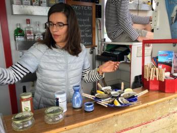 Olga Oros shucks and serves samples of the different brands of oysters from the Damariscotta River. SUZI THAYER/Boothbay Register