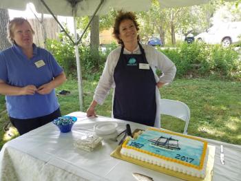 President Kathy Tibbetts, left, checks in with trustee Sarah Giles, who handed out cake and ice cream to visitors at the Aug. 6 celebration. KATRINA RICKERMANN/Boothbay Register