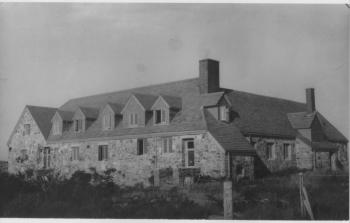 This view shows the east side of Greystones, the big house on Fisherman's Island. It sits 60 feet above the ocean and midway on a 400-foot expanse between the little harbor and the west side. The central windows below the dormers are the kitchen windows which were hit by the spray when the waves exploded on the shore 200 feet east and 60 feet below. Courtesy of the Boothbay Region Historical Society