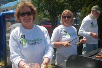 Sarah Giles, Stephanie Hawke and John Bertolet serve hamburgers for Rebuilding Together. ART MAYERS/Boothbay Register