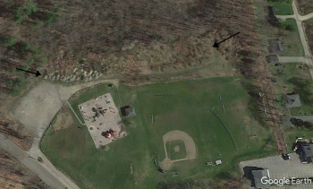 Pat Farrin and Tom Nickerson hope to draw some skilled volunteers to convert the piles of fill on the north side of Clifford Playground to usable fields. The area is shown between the dirt road and arrows. Courtesy of Google Earth