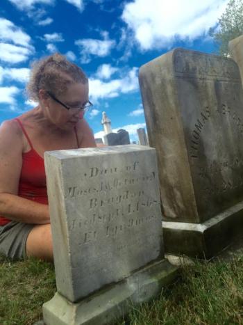 Denise Bizer cleans stones at Alna Cemetery Sept. 13. According to the one in the foreground, Adelaid, daughter of Moses and Octavie Bragdon, died 150 years ago this month, at 1. SUSAN JOHNS/Wiscasset Newspaper